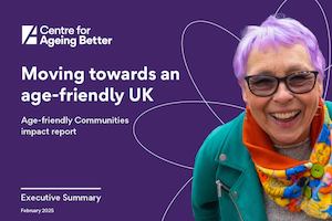 Older woman with purple hair smiling into the camera