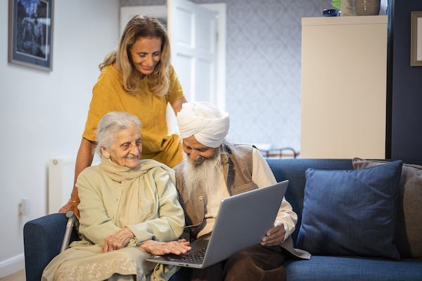 three older people looking at a laptop