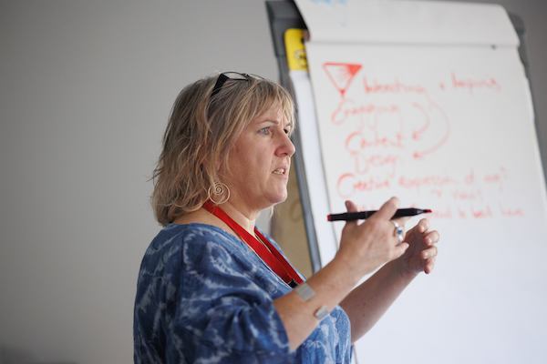 Woman teaching a class with a pen in her hand