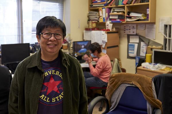 Woman standing in an office smiling at the camera
