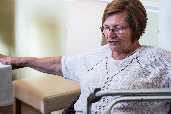 Lady sitting beside a zimmerframe