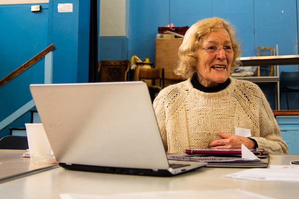 Woman seated at a table, using a laptop