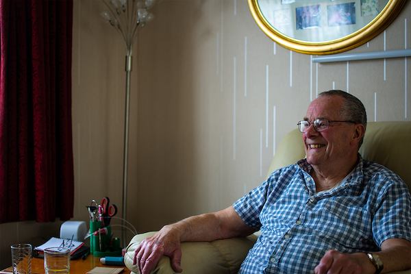 Older man sitting on chair in home