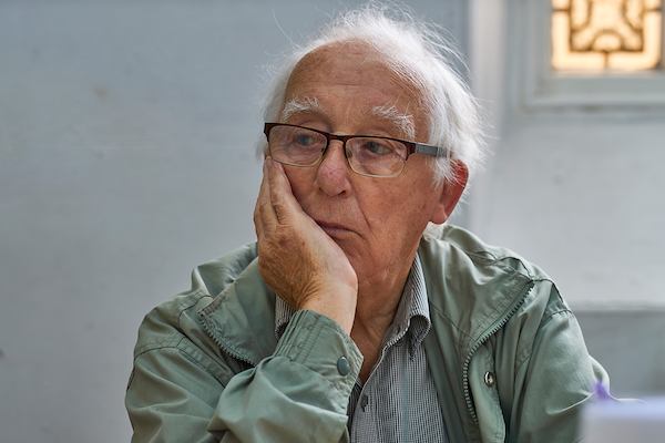 Elderly man sitting alone in thought.