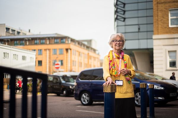 Older woman hospital volunteering standing outside hospital.