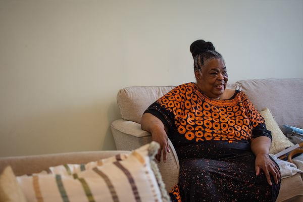 Woman seated on sofa at home.