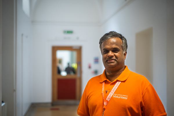 Older Indian male volunteer in hospital setting.