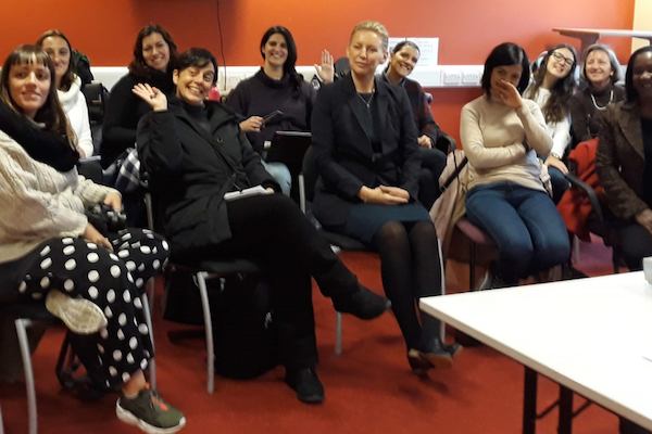 Women sitting in a room for a conference.