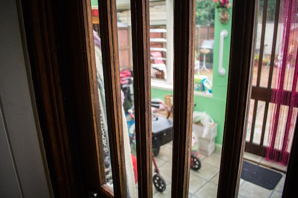 A home entrance with a grab rail and a rolling walker.