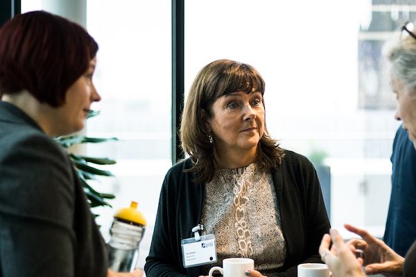 Three older women in a discussion during conference break.