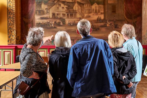 Group of elderly people in a museum looking at a work.
