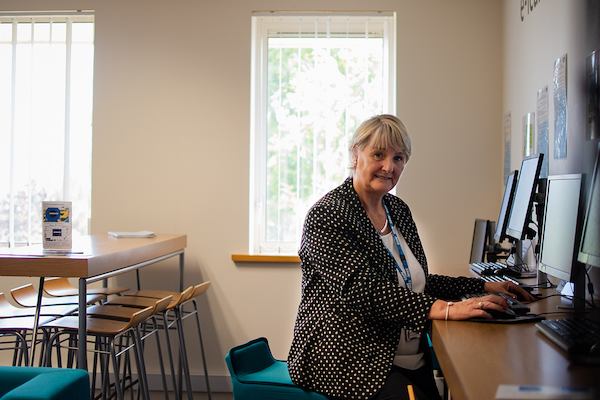 Older woman seated at computer.