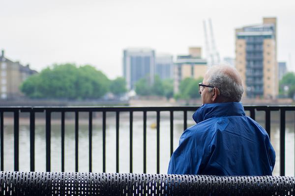 Older Asian man sitting on a bench