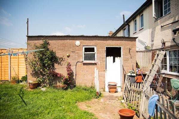 a sunny back garden that has lots of building equipment in