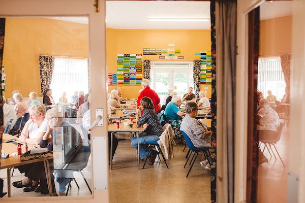 Group of older people sitting by tables