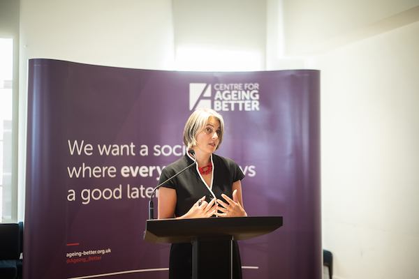 Anna Dixon on a podium giving a speech
