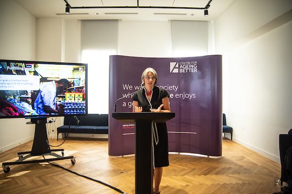Anna Dixon on a podium giving a speech
