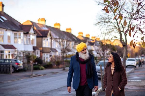 Older man and younger woman walking on street together