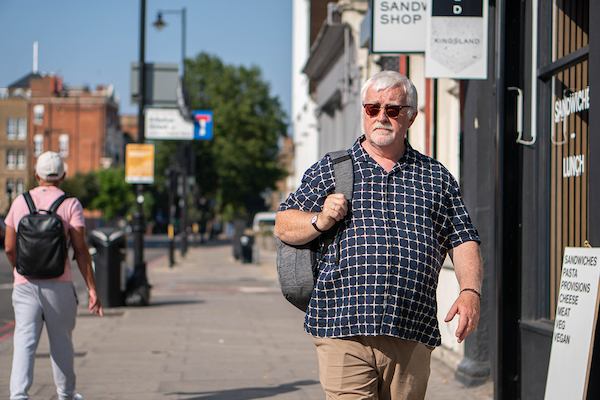 Older man walking with bag on shoulder