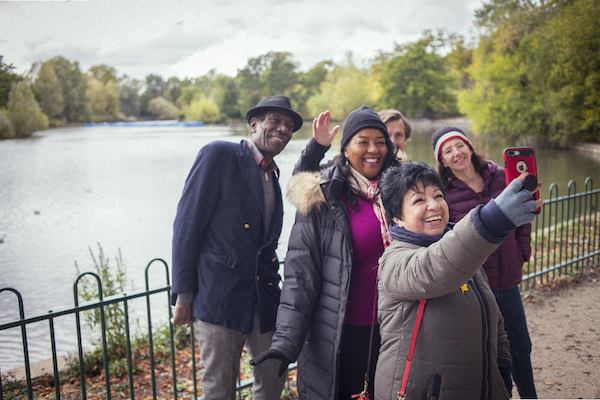 Older group of adults taking a selfie in front of a lake