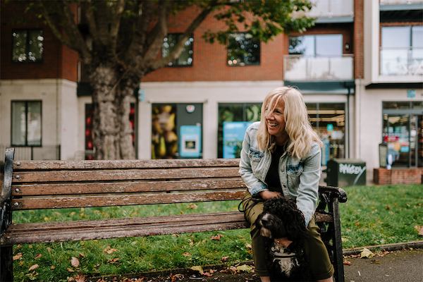 older woman sitting down with a dog