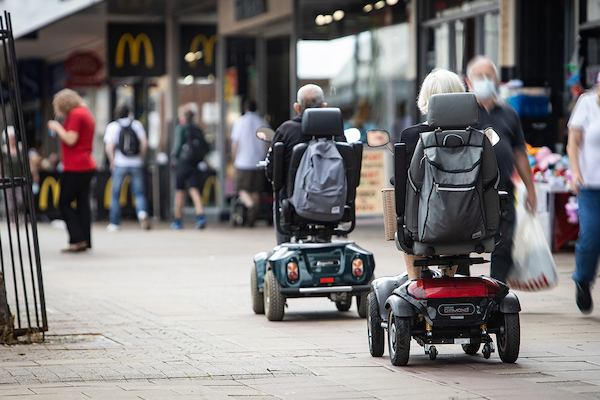 Older people on a mobility scooter on high street