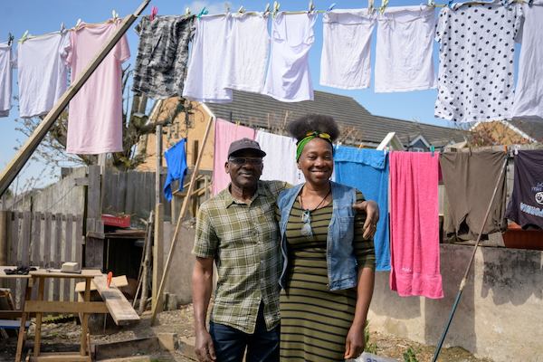 Older man and younger woman smiling in the garden in front of a washing line