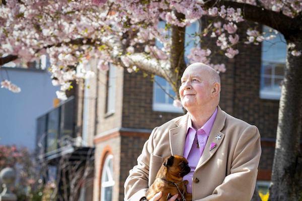 older man with his dog outside