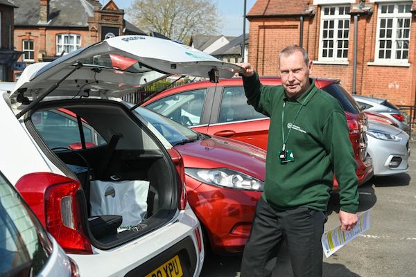 Older worker standing by car
