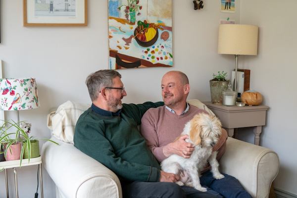 michael and his husband Johnny sitting together with their dog