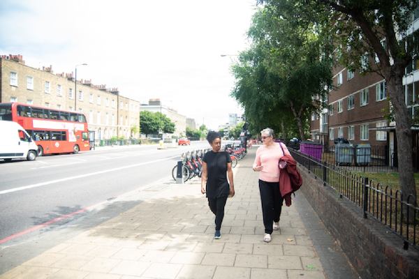 two older women walking together on a sunny street