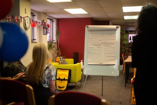 a group of people talking around a whiteboard