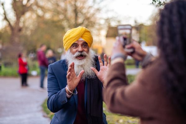 Woman taking a photo of an older man