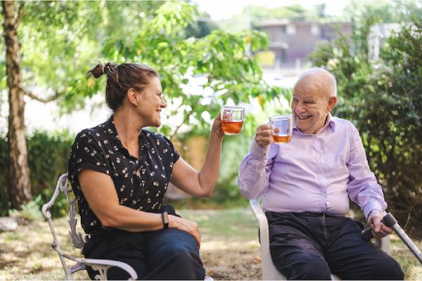 Older man and woman sitting together drinking tea