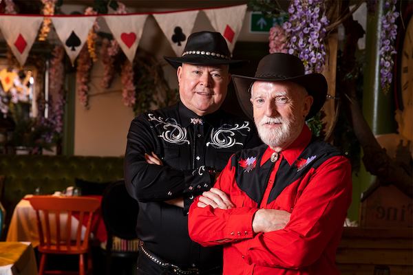 Patrick and David in their line dancing outfits smiling at the camera