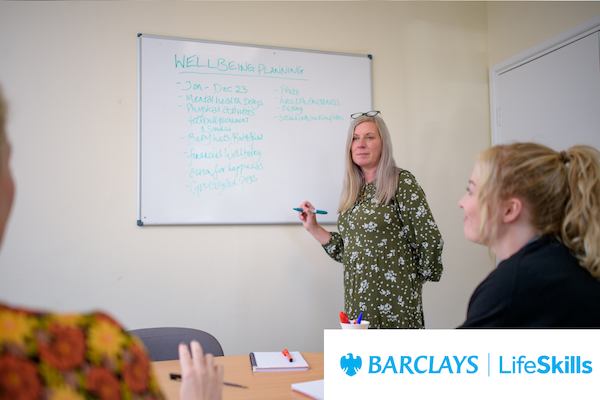 An older workers leading a meeting with a whiteboard