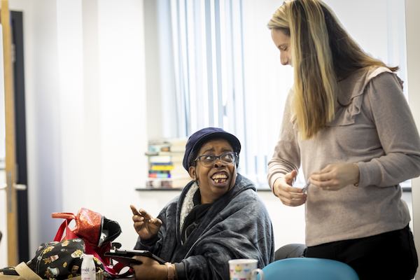 Two women chatting with an iPad in frame