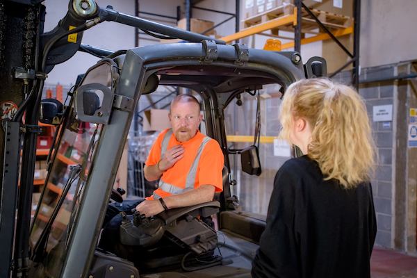 An older worker using a forklift