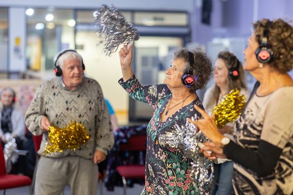 People dancing at silent disco with tinsel pompoms