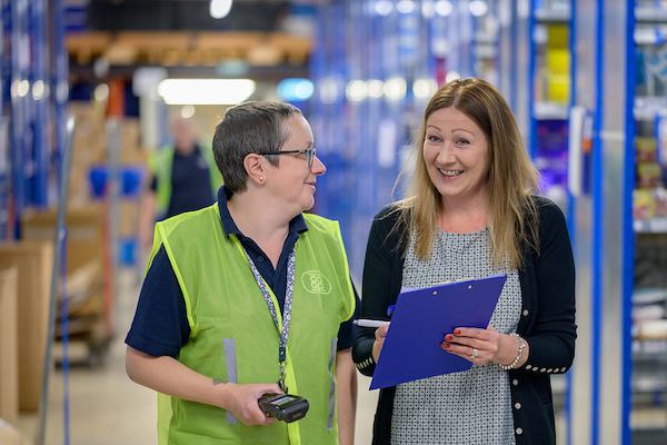 Two older women working with a clipboard