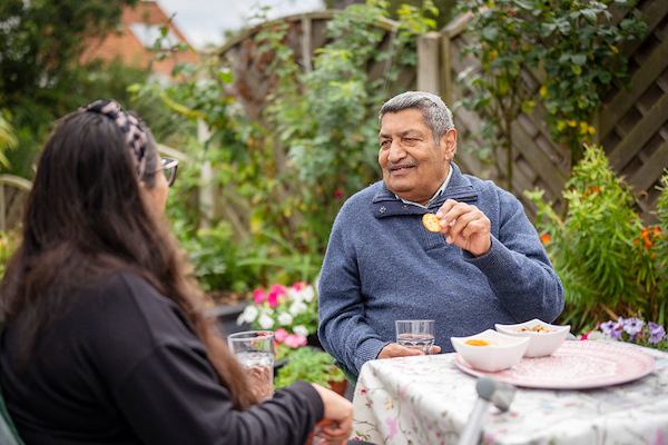 Older people outside having snacks