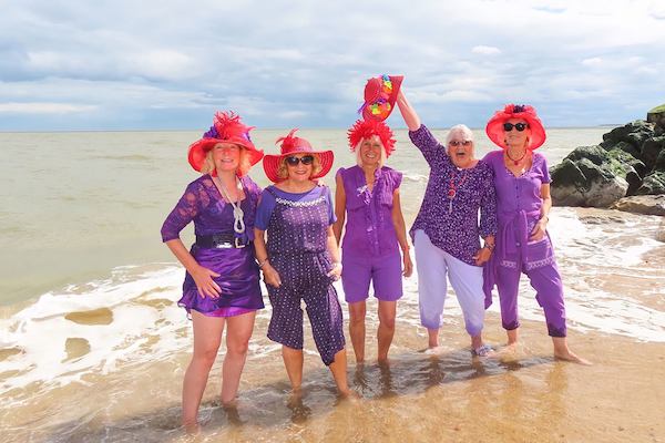 Five people on the beachThe winning photo of North Norfolk’s Age Positive Photography Competition. ’Red Hat Ladies’ by Sally Redgrave.