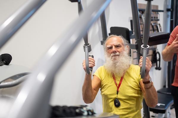 Older man using weight machine