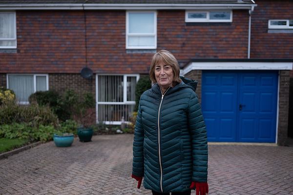 Older-woman-standing-outside-house