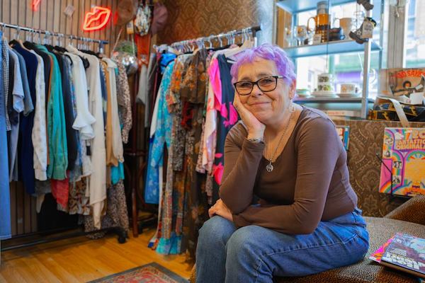 Woman in clothing shop smiling at camera