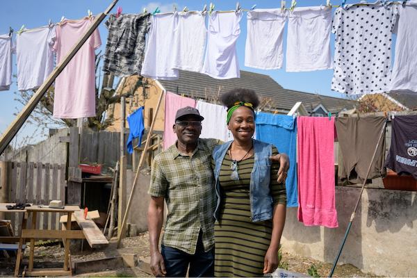 An older man and his daughter hang clothes on a washing line