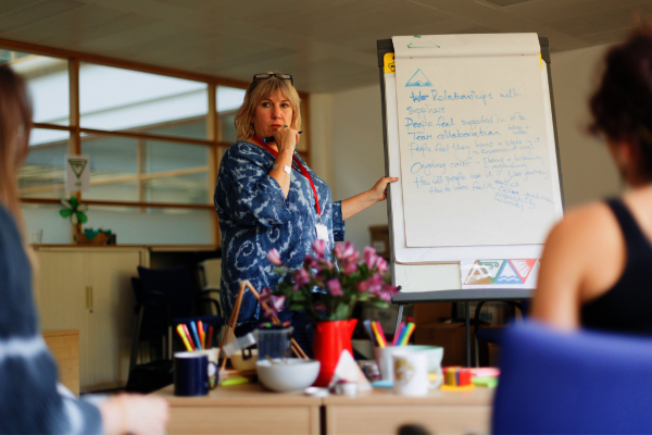 An older woman writing on a board